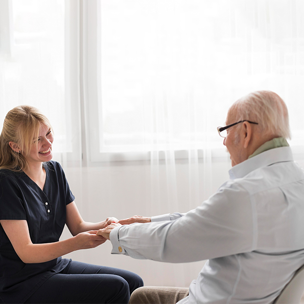 Nurse checking senior woman’s blood pressure in bright home bedroom